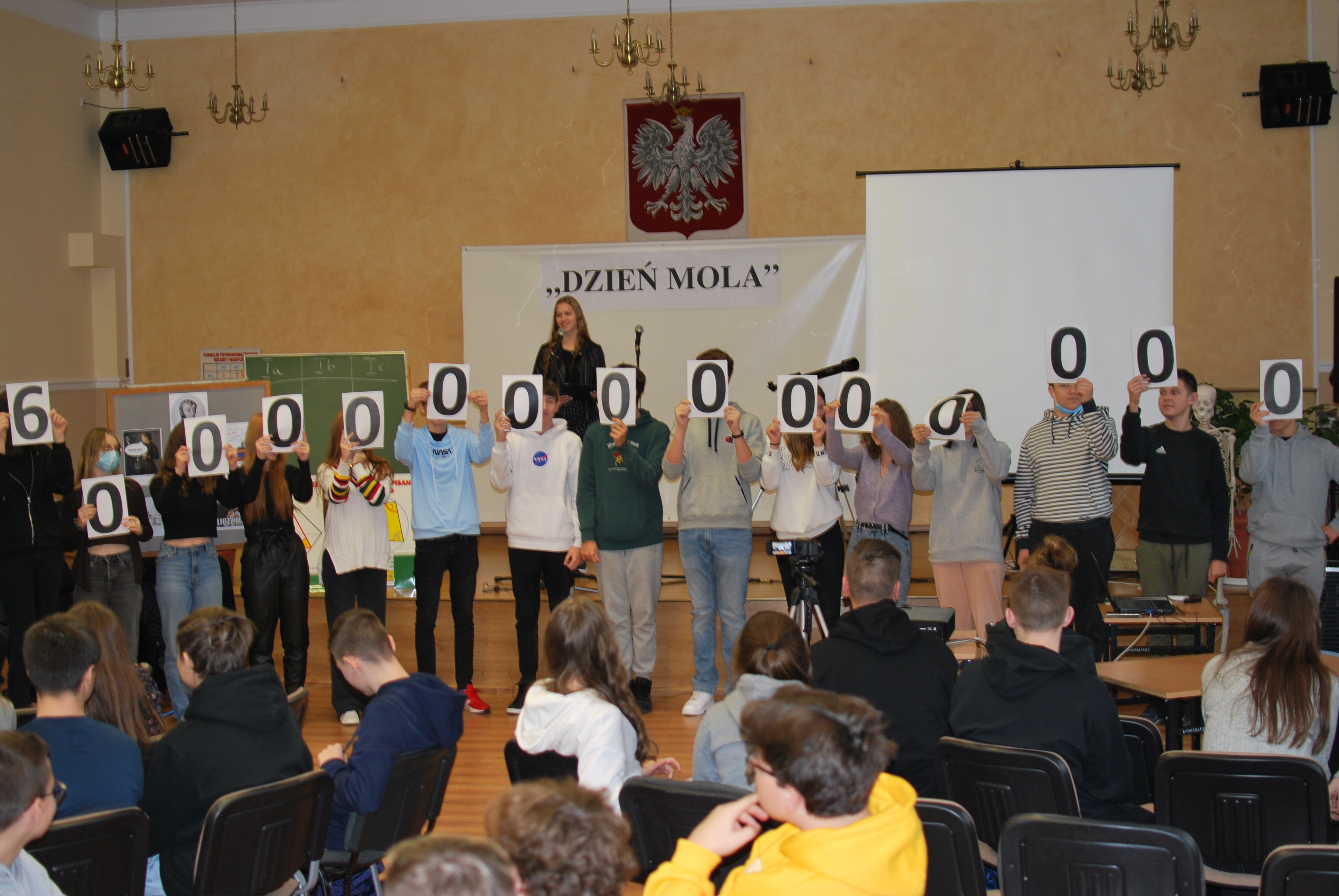 Młodzież stoi z Panią przed godłem